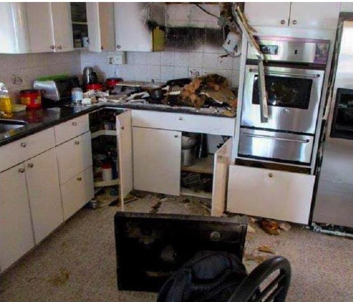 burned wall, kitchen cabinets and appliances on floor