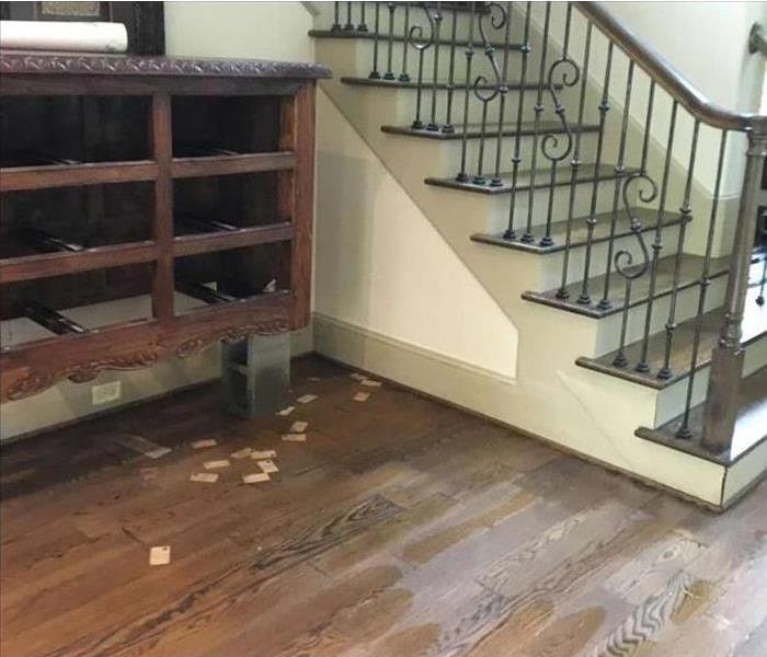 water on damaged wood floor and stair area