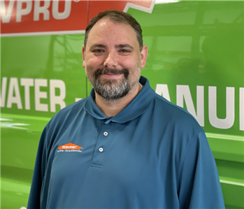 Project Manager Standing in front of Servpro Fleet