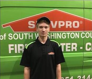 Male SERVPRO employee standing in front of a SERVPRO van.  