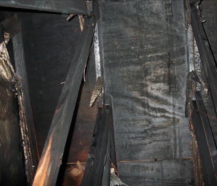 burned trusses and sheathing in an attic, black